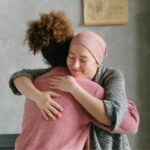 woman with a head scarf, hugging a friend