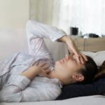 woman laying in bed in pain