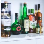 a shelf lined with assorted bottles of alcohol/ spirits